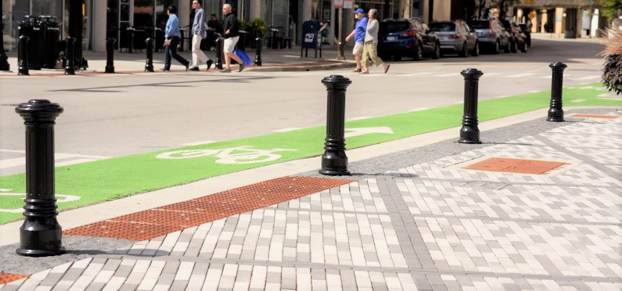 Bollards and DWPs line the side of a street near a bike lane