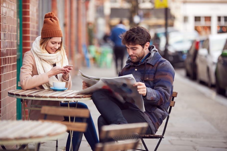 A couple spends time at a café on a street