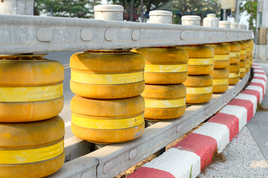 A guardrail has a series of rotating drums to help redirect a sideswiping car