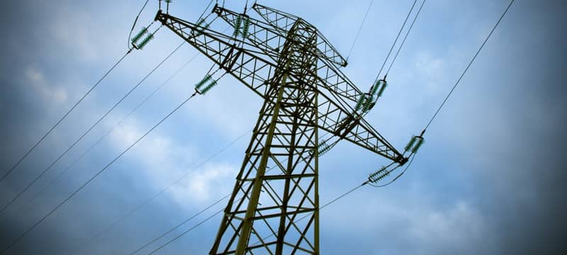 skyline with power lines running to a large transmission tower