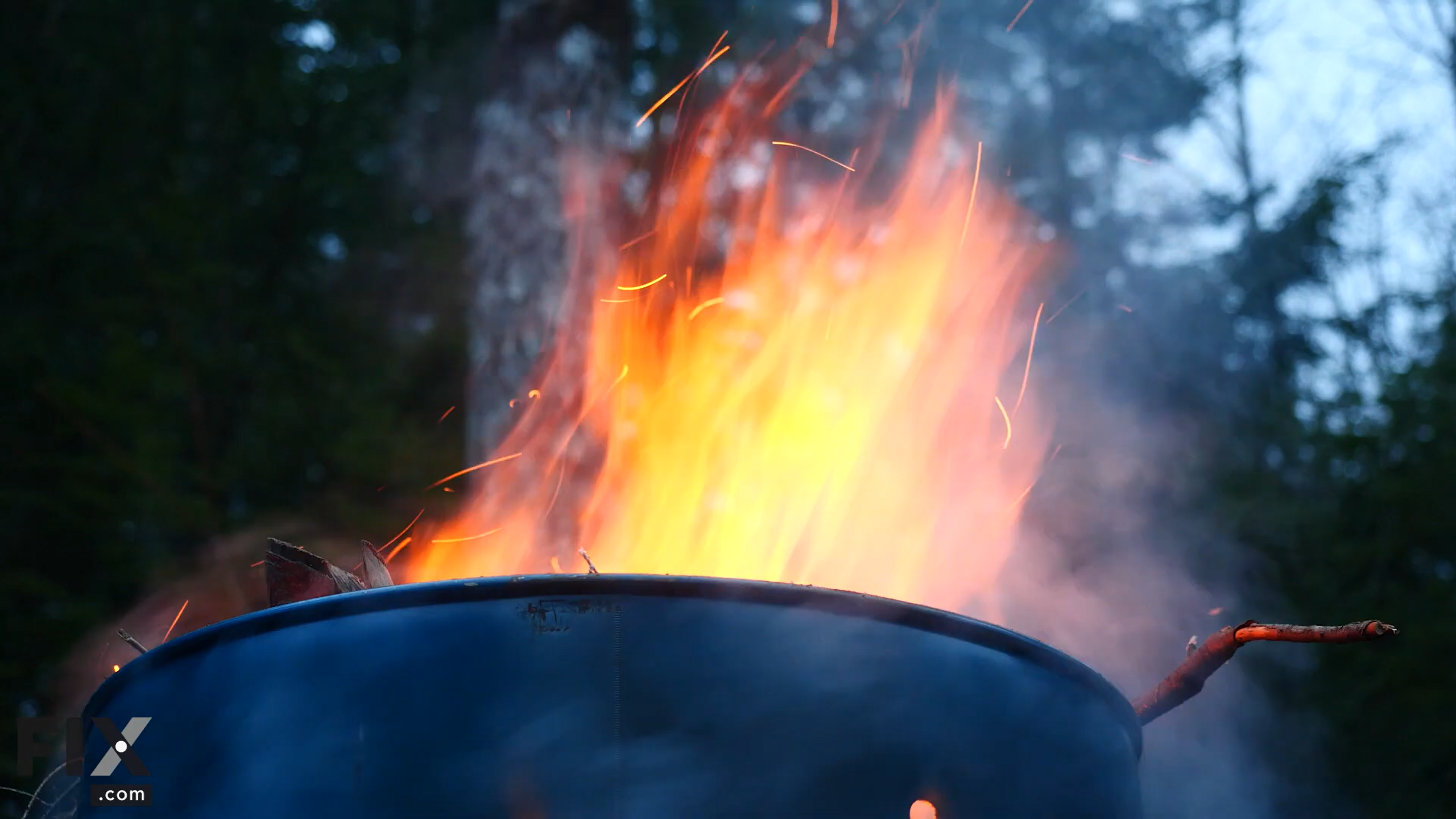 Barrel with burning twigs sticking out of its top.