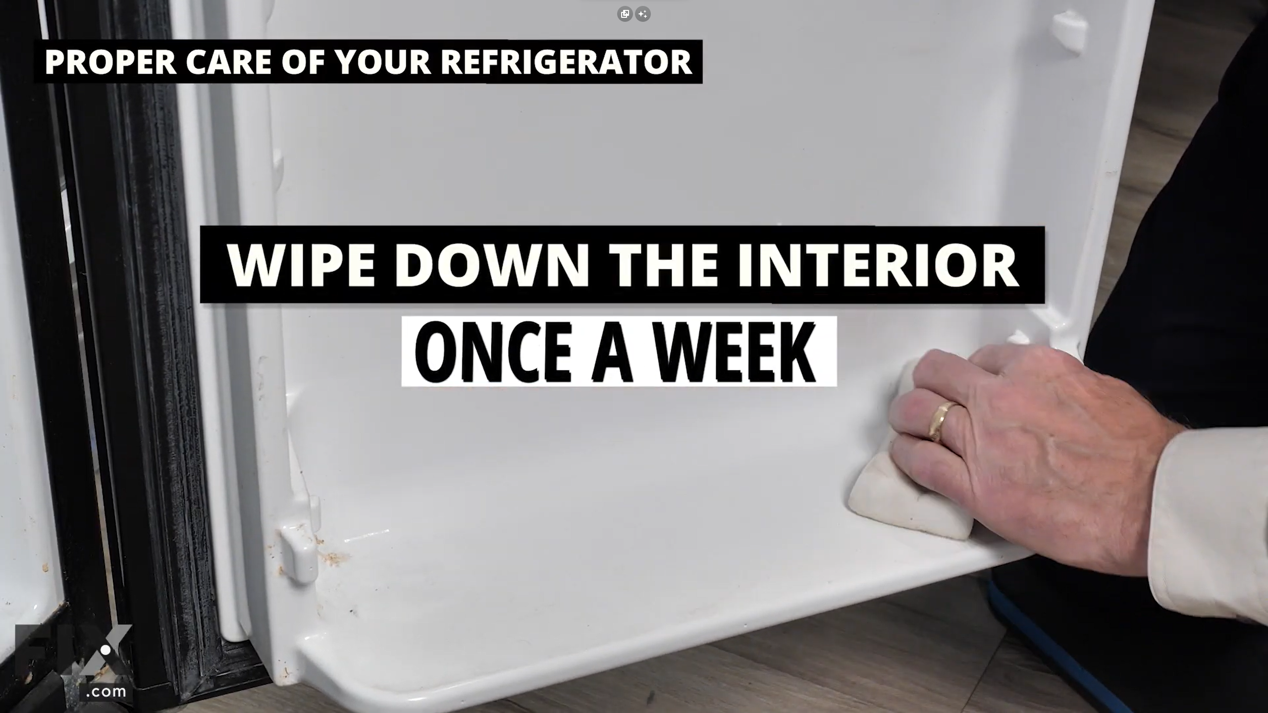 Hand using a cloth to wipe down the interior of a fridge shelf.